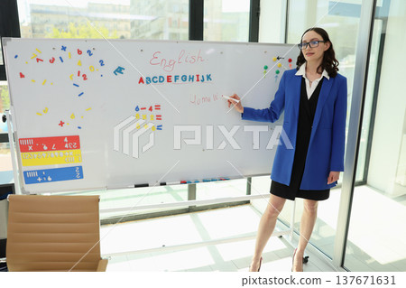 Bright and engaging English lesson taking place in a modern classroom with colorful learning tools and an enthusiastic teacher 137671631