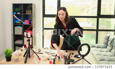 Creative makeup artist organizes colorful cosmetics in a bright studio filled with natural light and stylish decorations 137671635