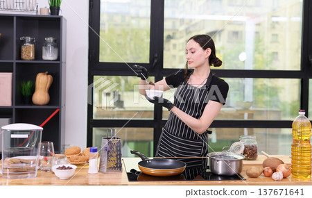 Cooking delicious meals in a bright, modern kitchen while preparing ingredients and enjoying the culinary adventure Cooking delicious meals in a bright, modern kitchen while preparing ingredients and enjoying the culinary adventure 137671641
