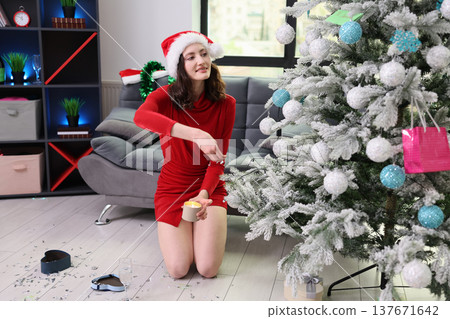 Festive woman decorating Christmas tree with care in cozy living room, celebrating holiday cheer with joy and warmth Festive woman decorating Christmas tree with care in cozy living room, celebrating holiday cheer with joy and warmth 137671642
