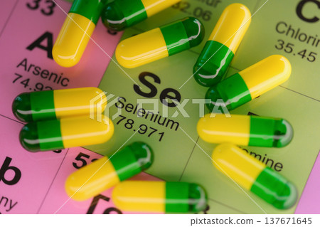 Colorful capsules resting on a vibrant periodic table with a focus on selenium 137671645