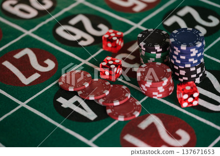 Excitement at the roulette table with vibrant chips and dice awaiting the next big win during a lively casino night Excitement at the roulette table with vibrant chips and dice awaiting the next big win during a lively casino night 137671653