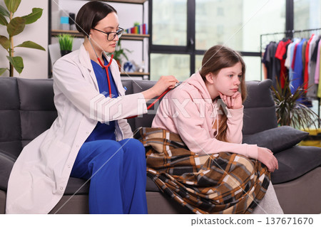 Caring doctor checks the health of a young girl during a chilly day indoors Caring doctor checks the health of a young girl during a chilly day indoors 137671670