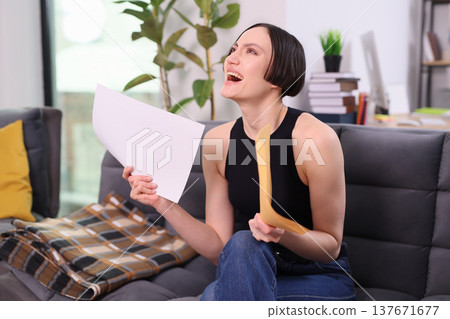 Exciting moment of joy and surprise as woman celebrates good news in cozy living room Exciting moment of joy and surprise as woman celebrates good news in cozy living room 137671677