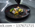 Exquisite seafood dish with salmon fillet broccoli and radish on a black designer plate 137671715