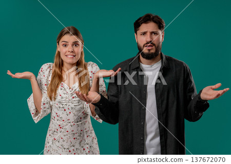 Confused Young Couple Shrugging Shoulders In Uncertainty While Looking At Camera 137672070