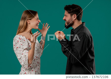 Grumpy blonde woman yelling with man. Irritated boyfriend, young couple on green 137672106