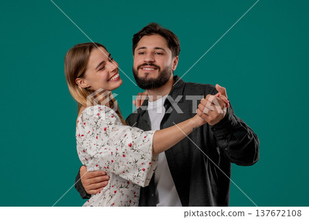 Romantic date - couple in love dancing closely together, smiling, holding hands Romantic date - couple in love dancing closely together, smiling, holding hands 137672108