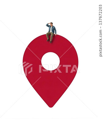 A miniature man is sitting on a red map pin, looking around. A miniature man is sitting on a red map pin, looking around. 137672203