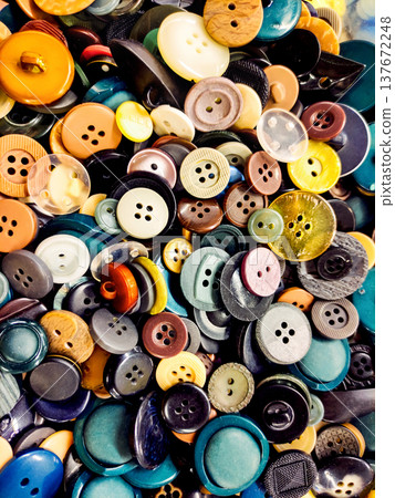 Bright vertical background with many colorful sewing buttons photographed from above in close-up. Suitable for sewing, tailoring, haberdashery, textile and craft themes. 137672248