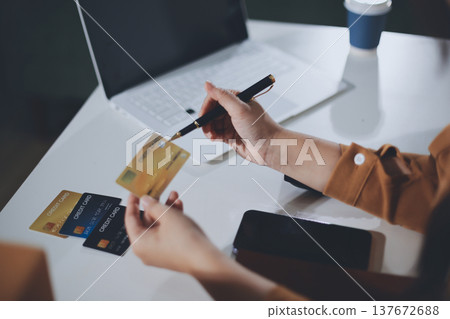 Online payment, Hands of woman holding a credit card and using smart phone for online shopping Online payment, Hands of woman holding a credit card and using smart phone for online shopping 137672688