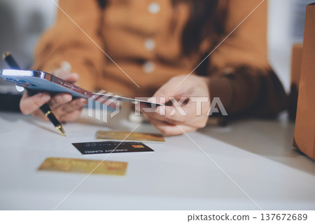 Online payment, Hands of woman holding a credit card and using smart phone for online shopping 137672689