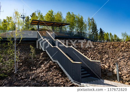 Modern Outdoor Staircase Leading to Observation Deck on Rocky Hillside With Trees and Blue Sky Modern Outdoor Staircase Leading to Observation Deck on Rocky Hillside With Trees and Blue Sky 137672820