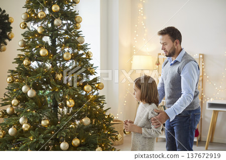 Father And Son Decorating A Tree For Christmas Or New Year Father And Son Decorating A Tree For Christmas Or New Year 137672919