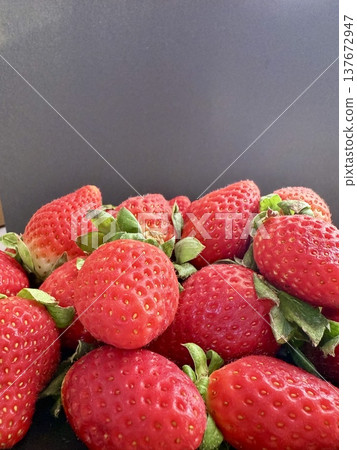 Close-up shot of fresh and large strawberries placed on a black plate. Delicious and healthy food. Close-up shot of fresh and large strawberries placed on a black plate. Delicious and healthy food. 137672947