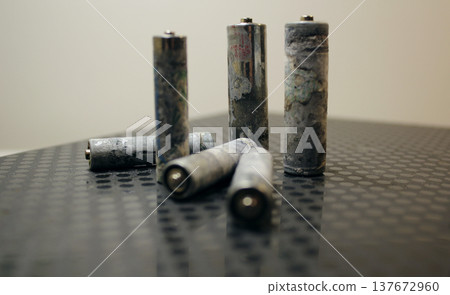 Corrosion reaction on the old batteries soft focus. Corroded Batteries on Dark Surface Corrosion reaction on the old batteries soft focus. Corroded Batteries on Dark Surface 137672960