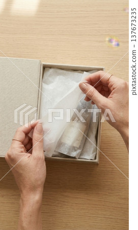Hands Lifting Delicate Tissue Paper in Luxury Box Reveal Hands Lifting Delicate Tissue Paper in Luxury Box Reveal 137673235