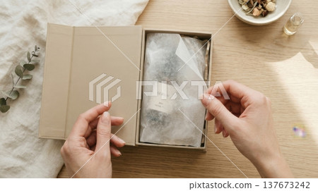 Hands Lifting Delicate Tissue Paper in Luxury Box Reveal Hands Lifting Delicate Tissue Paper in Luxury Box Reveal 137673242