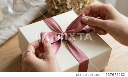 Manicured Hands Untying Silk Ribbon on Premium Gift Box Manicured Hands Untying Silk Ribbon on Premium Gift Box 137673282