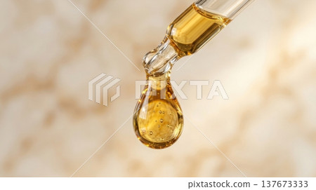 Golden Argan Hair Oil Drop from Glass Pipette Macro Shot Golden Argan Hair Oil Drop from Glass Pipette Macro Shot 137673333