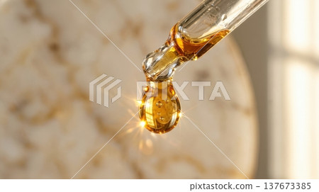 Golden Argan Hair Oil Drop from Glass Pipette Macro Shot 137673385