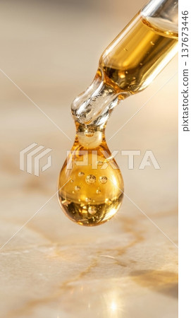 Golden Argan Hair Oil Drop from Glass Pipette Macro Shot Golden Argan Hair Oil Drop from Glass Pipette Macro Shot 137673446