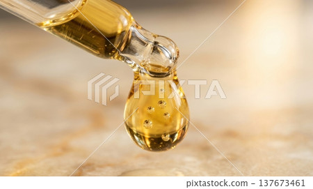 Golden Argan Hair Oil Drop from Glass Pipette Macro Shot 137673461