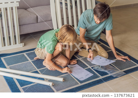 Father and older brother assembling a baby crib at home, preparing for a newborn arrival. Warm family moment full of care and anticipation. Parenthood, sibling bond and home preparation concept Father and older brother assembling a baby crib at home, preparing for a newborn arrival. Warm family moment full of care and anticipation. Parenthood, sibling bond and home preparation concept 137673621