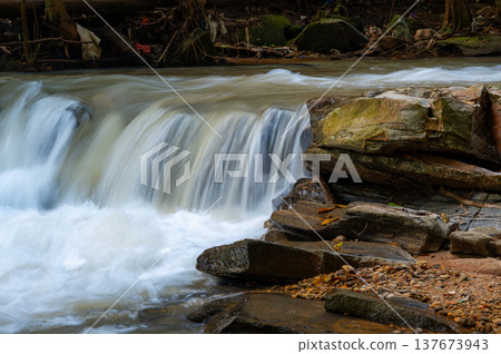 Mae Sa waterfalls near Chiang Mai Thailand surrounded by lush green jungle. Flowing water and tropical forest create serene nature scene, ideal for travel, adventure and eco-tourism concepts. 137673943
