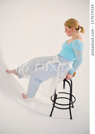 Contemplative woman dressed in pastel colors in studio environment Contemplative woman dressed in pastel colors in studio environment 137674334