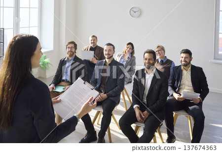 Smiling business team listening to coach during office training seminar session 137674363