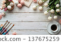 A blank white canvas on a rustic wooden table, with watercolors, flowers, and Easter decor. Concept art, education, DIY creativity, Easter decor. 137675259