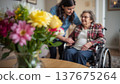 A daughter wishes her wheelchair-bound mother a Happy Mother's Day. An elderly woman in a wheelchair at home. Conceptual themes of healthcare, aging, home care, and Mother's Day greetings. 137675264