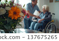 A daughter wishes her wheelchair-bound mother a Happy Mother's Day. An elderly woman in a wheelchair at home. Conceptual themes of healthcare, aging, home care, and Mother's Day greetings. 137675265