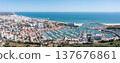 People enjoy tourism in Vilamoura as they visit the marina, observe boats, and take in views of the surrounding coastal landscape and city buildings Aerial panorama 137676861