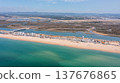 View of praia de Faro and Ria Formosa in Faro, Portugal from above showing water, sandy beach, and land structures on a clear day 137676865