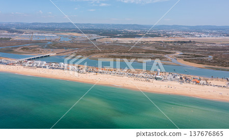 View of praia de Faro and Ria Formosa in Faro, Portugal from above showing water, sandy beach, and land structures on a clear day View of praia de Faro and Ria Formosa in Faro, Portugal from above showing water, sandy beach, and land structures on a clear day 137676865