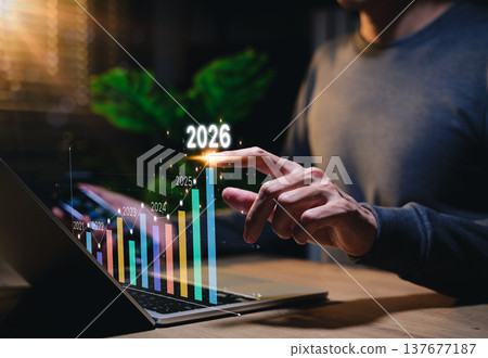 The 2026 New Year business goals concept. Businessman analyzes graph of trend market growth in 2026 and plans business growth and profit increases. calculates financial data for long-term investments. The 2026 New Year business goals concept. Businessman analyzes graph of trend market growth in 2026 and plans business growth and profit increases. calculates financial data for long-term investments. 137677187