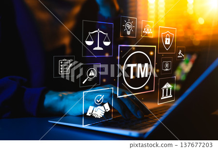 Trademark protection concept. Person typing on laptop surrounded by icons of TM, copyright, intellectual property, patent, legal scale, and cybersecurity representing brand security, legal compliance, 137677203