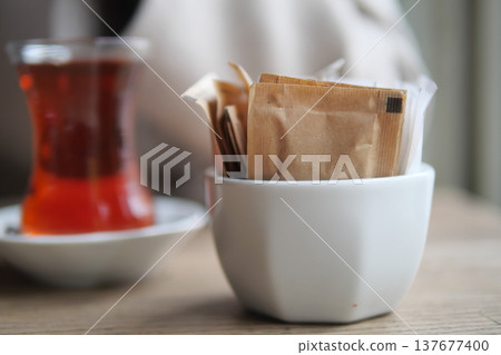 Tea served with sugar packets in a cafe setting Tea served with sugar packets in a cafe setting 137677400