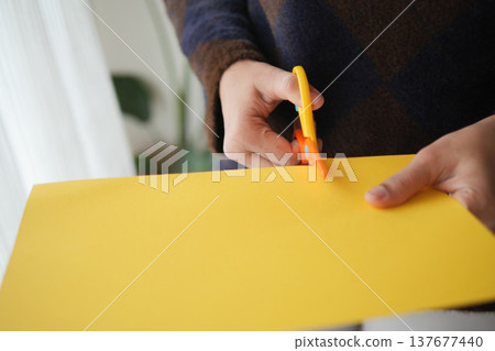 Cutting paper with scissors in a bright room 137677440