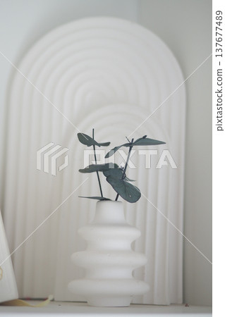 Decorative vase with plant on a shelf in a home setting 137677489