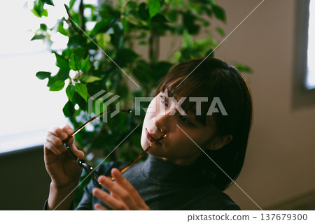 A woman holds her glasses in her hand and thinks. A woman holds her glasses in her hand and thinks. 137679300