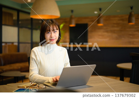 一位女士在辦公室使用筆記型電腦工作。 137679302