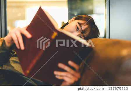 一位女士在沙發上看書的臉 137679313