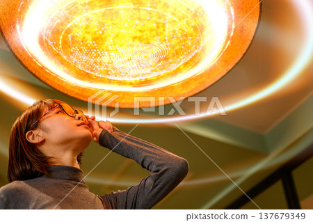 一位女子抬頭望著橘色的燈光。 137679349