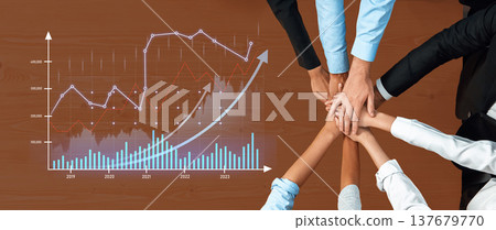 Team Collaboration at a Business Meeting Analyzing Growth Trends and Data Visualization with Hands Stacked Together on a Wooden Table Scalp 137679770