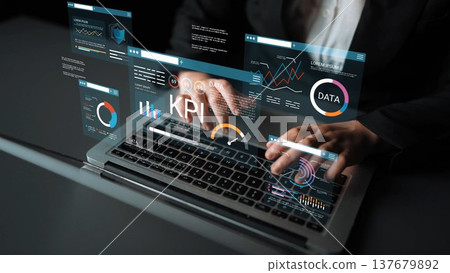 Business professional analyzing data metrics on laptop with digital graphs and charts for performance improvement and strategic planning in modern office Gluon 137679892