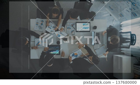 Aerial View of Diverse Business Team Collaborating on Data Analysis and Presentations in Modern Office Space with Laptops and Charts. Raster 137680000