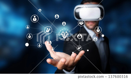 Businessman in Virtual Reality Headset Interacting with Digital Network of Icons Representing People and Connections in Modern Technology Environment Gluon Businessman in Virtual Reality Headset Interacting with Digital Network of Icons Representing People and Connections in Modern Technology Environment Gluon 137680316